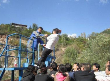 图为员工在进行拓展器材训练中
